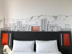 a bedroom with a mural of a city on the wall at easyHotel Malaga City Centre in Málaga