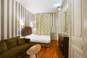 
a living room with a couch and a lamp at Hôtel Vaubecour in Lyon
