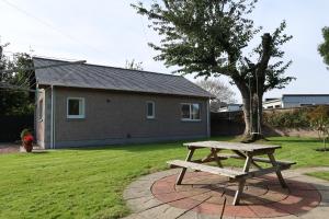 a wooden picnic table in front of a house at Corunna Cottage in Inverness