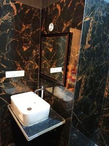 W łazience znajduje się biała umywalka i lustro. w obiekcie HOTEL GREEN HILLOCK w mieście Alwar