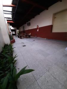 um corredor vazio de um edifício com mesas e cadeiras em InstaLate Hostel em Santa Fé