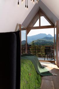sypialnia z łóżkiem i dużym oknem w obiekcie Green Deer Premium w Zakopanem