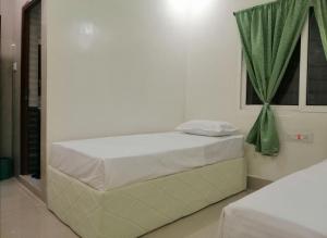 a white bedroom with a bed with a window at RAJHAT MARANAO House in Bodh Gaya