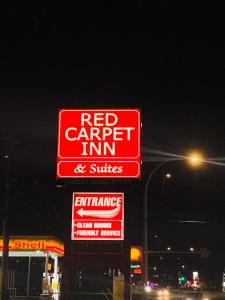un cartello di una locanda per la sosta delle carrozze sul lato di un distributore di benzina di Red Carpet Inn & Suites a Calgary