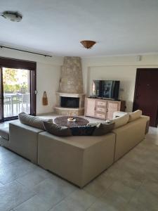 a living room with a large couch and a fireplace at Villa Sandra in Kriopigi
