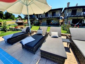 a patio with two couches and an umbrella at Villa Sandra in Kriopigi