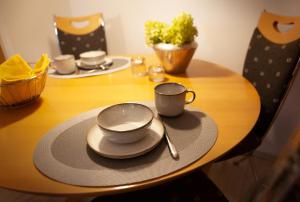 una mesa de madera con dos tazas y platos. en Ferienwohnung Schlossblick, en Eisfeld