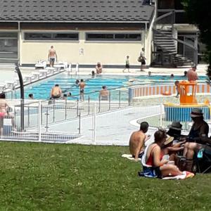 eine Gruppe von Menschen, die um einen Pool herum sitzen in der Unterkunft Le Chalet des Fées in Valmorel