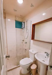 a bathroom with a shower and a toilet and a sink at The NEST, Tagaytay in Tagaytay