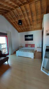 ein Schlafzimmer mit einem Bett und einem Sofa in einem Zimmer in der Unterkunft Sara Village in São Roque do Pico