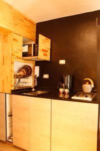 una cocina con armarios de madera y una pared negra en Dpto Céntrico - Estilo Indutrial en San Miguel de Tucumán