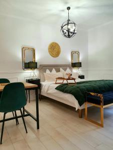 a bedroom with a bed and a table with a green blanket at RoomChic - Les Ambassadeurs in Vichy