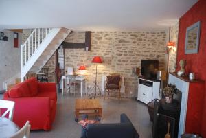 een woonkamer met een rode bank en een tafel bij Ty Kergate in Sulniac