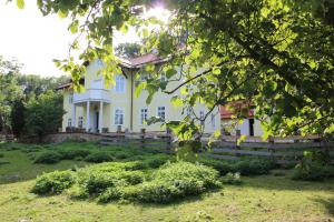 una casa blanca con una valla delante en Lovecký zámeček pod Milešovkou, en Teplice