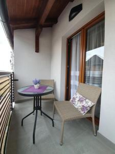 mesa púrpura y 2 sillas en el balcón en Zlatibor Hills LARA, en Zlatibor
