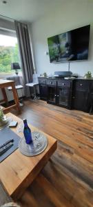 sala de estar con mesa y TV en Meisters Schick im Stryck Willingen en Willingen