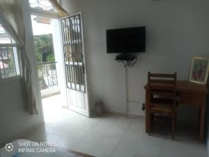 a living room with a television and a table and chair at Residences Hotels Sejours Affaires in Abidjan