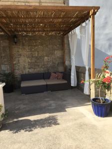 a couch sitting under a wooden pergola at Mood Farmhouse Mythology in Għarb