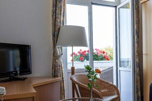 a room with a room with a window and a television at Strandhaus WOTAN in Kühlungsborn