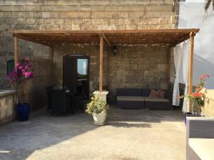 an outdoor patio with a couch and a table at Mood Farmhouse Mythology in Għarb