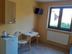 a kitchen with a table and chairs and a window at Pokoje gościnne u Kaski in Krościenko