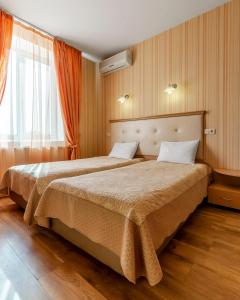 1 dormitorio con 2 camas y ventana en Гостиница Siesta Киев, en Kiev