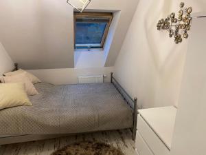 a small bedroom with a bed and a window at GOJA in Sztutowo