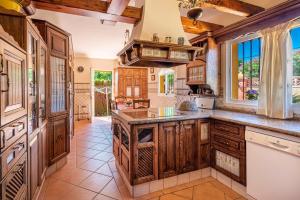 una cocina con armarios de madera y una gran isla central en Villa Amapola, en Coín