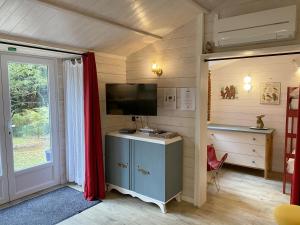 a room with a television and a desk and a door at Le Cabanon de Chessy in Chessy