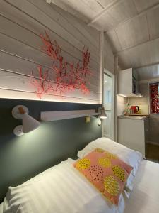 a bedroom with a bed with a fish on the wall at Le Cabanon de Chessy in Chessy