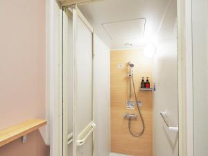 La salle de bains est pourvue d'une douche et d'une porte en verre. dans l'établissement THE POCKET HOTEL Kyoto Karasuma Gojo, à Kyoto