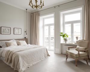 a white bedroom with a bed and a chair at Lwowska Studios - STAYINWARSAW in Warsaw