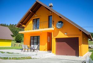 une maison avec un garage, une table et des chaises dans l'établissement Holiday Home Lisica, à Žabljak