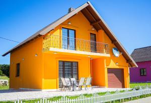 une maison orange avec une table et des chaises dans l'établissement Holiday Home Lisica, à Žabljak