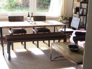 Sala de estar con 2 mesas y 2 botellas de vino en Ferienwohnung am Kunstberg 29 en Altenau
