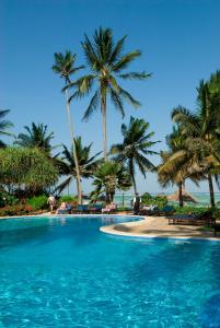 una piscina con palmeras y una playa en Breezes Beach Club and Spa en Bwejuu