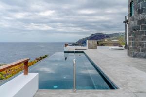 a swimming pool on the edge of a house overlooking the ocean at Lighthouse on La Palma Island in Barlovento