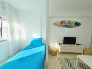 een slaapkamer met een bed en een surfplank aan de muur bij Peniche's Blue & Yellow in Peniche
