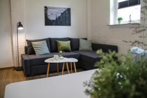 ein Wohnzimmer mit einem Sofa und einem Tisch in der Unterkunft Alte Käserei Ferienwohnungen in Flensburg