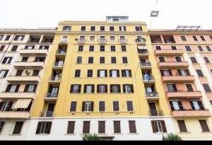 ein hohes gelbes Gebäude mit vielen Fenstern in der Unterkunft django apartament in Rom