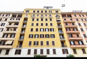 wysoki żółty budynek z wieloma oknami w obiekcie django apartament w Rzymie