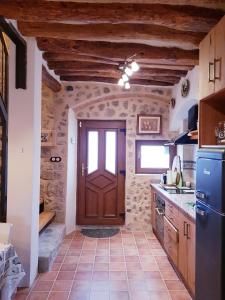 a kitchen with a brown door and a tile floor at La Ultima Casa Masboquera in Mas Boquera