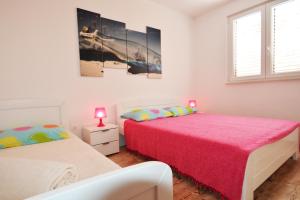 a bedroom with two beds and a window at Apartments Barbati in Kustići
