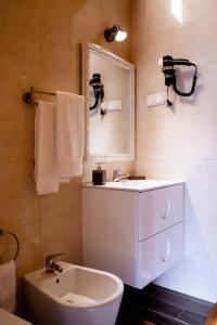 een badkamer met een wastafel, een toilet en een spiegel bij Montanhas do Xisto - Casa da Eira in Candal