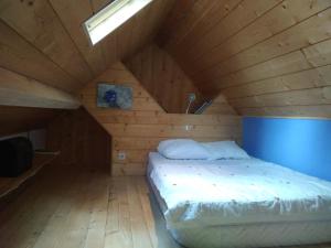 a bed in a room with a wooden ceiling at Le panoramique in Campan