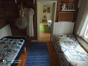 a bedroom with a bed and a dress hanging in a room at Laukkumäki farm in Iisalmi