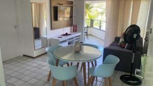 ein Wohnzimmer mit Tisch, Stühlen und Sofa in der Unterkunft Ancorar Flat Porto de Galinhas - Flat 1203-5205 in Porto De Galinhas