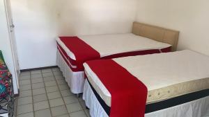 2 Betten in einem rot-weißen Zimmer in der Unterkunft Ancorar Flat Porto de Galinhas - Flat 1203-5205 in Porto De Galinhas + 60 Fotos