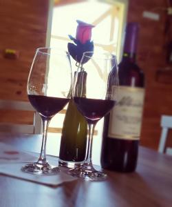 烏魯比西的住宿－Cabanas Fazenda da Raia，两杯红葡萄酒,旁边是一瓶葡萄酒
