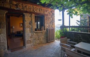 a stone building with a door and a table and chairs at Oikies Katogi in Pramanta